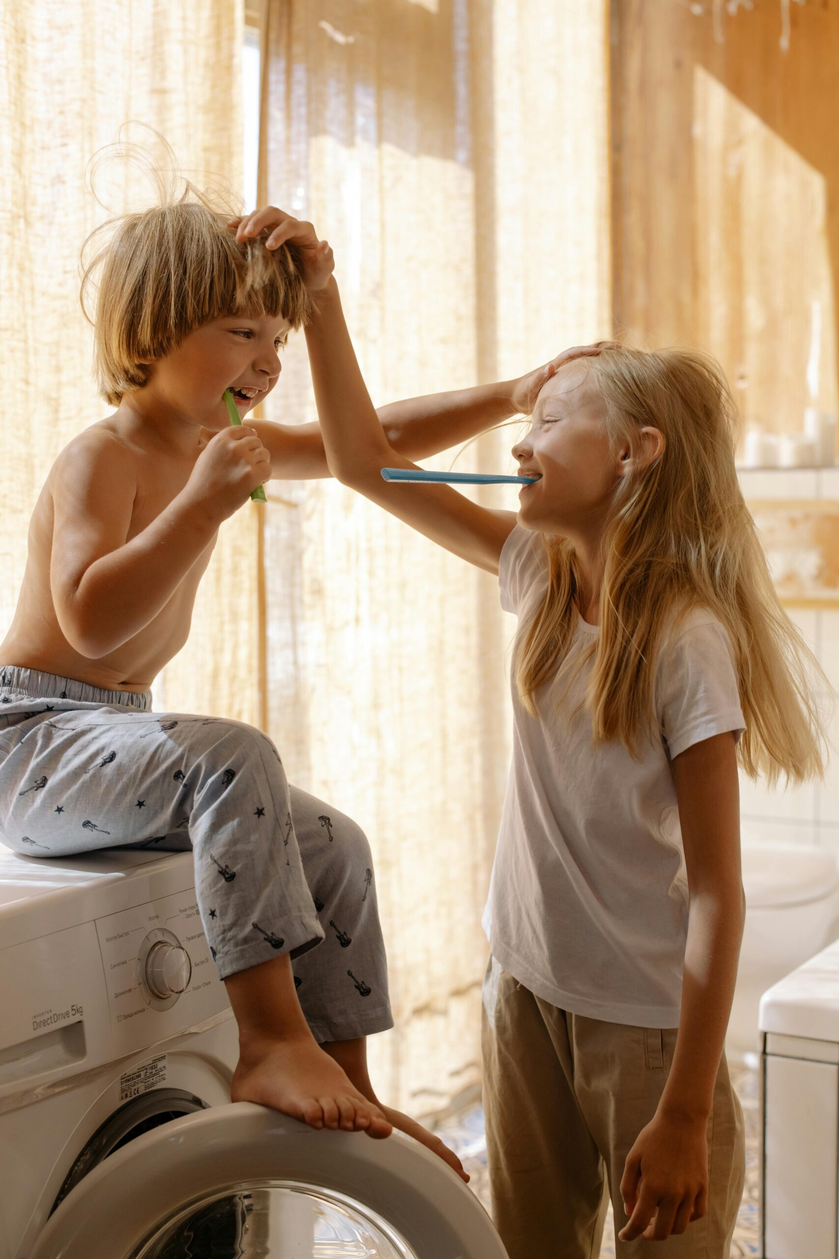 Two children sharing a fun and playful moment brushing their teeth in the bathroom.